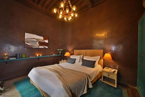 a bedroom with a large bed and a chandelier at Riad Dar One in Marrakesh