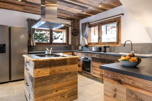 a kitchen with wooden cabinets and a bowl of fruit on the counter at Chalet Saint Maurice - piscine privée & jacuzzi in Champagny-en-Vanoise