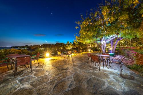 a patio with tables and chairs at night at PrideInn Flamingo Beach Resort & Spa Mombasa in Mombasa