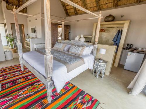 a bedroom with a bed and a rug at The Wild Blue Lodge SAFARI & SPA in Hoedspruit