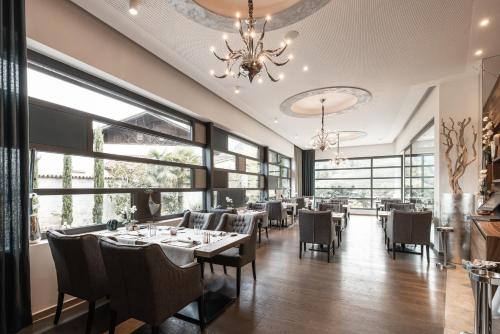 a dining room with tables and chairs and a chandelier at ALPIANA - green luxury Dolce Vita Hotel in Vollan