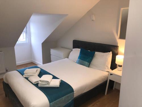 um quarto com uma cama grande e toalhas em Town Centre Apartment with FREE Parking em Loughborough