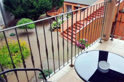 a balcony with a glass table and a wrought iron fence at Rezydencja 5 Dębów in Międzyzdroje