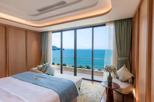 um quarto de hotel com uma cama e uma grande janela em Fleur de Lys Hotel Quy Nhon em Quy Nhon