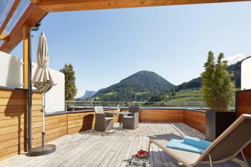 a balcony with a view of mountains at ALPIANA - green luxury Dolce Vita Hotel in Vollan