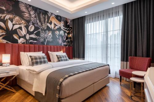 a bedroom with a large bed and a large window at Motif Hotel Çeşme in Çeşme