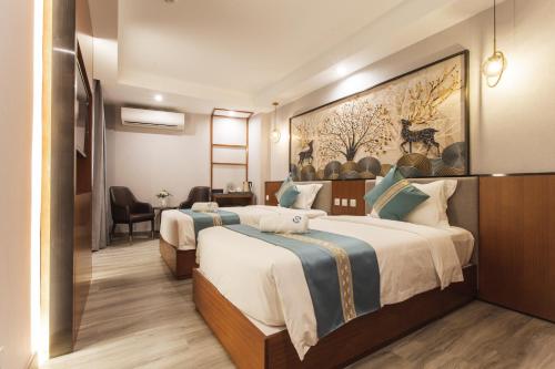 a hotel room with two beds and a desk at Thapae Twins Hotel in Chiang Mai