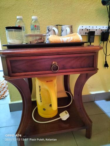 a table with a yellow vacuum under it at Hotel Murah Pasir Puteh in Pasir Puteh