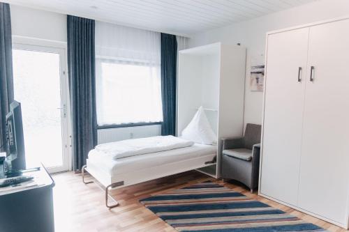 - une chambre avec un lit, un canapé et une chaise dans l'établissement Apartment-EG-07, à Darmstadt