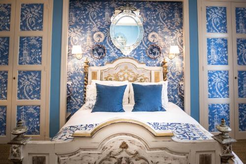a bedroom with a blue and white bed with a mirror at Carcassonne Bed and Breakfast du Palais in Carcassonne