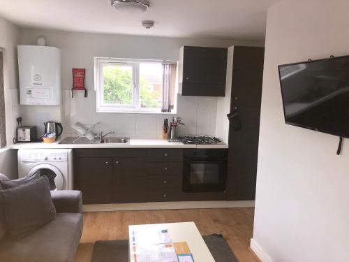a kitchen with a sink and a stove top oven at Large 1st Floor Open Plan Apartment in Loughborough