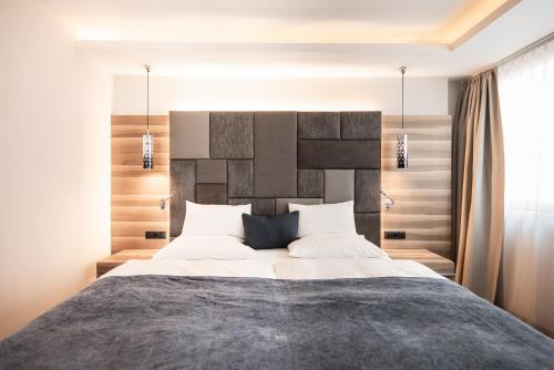 a bedroom with a large bed with a large headboard at ALPIANA - green luxury Dolce Vita Hotel in Vollan