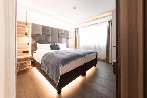 a bedroom with a large bed and a window at ALPIANA - green luxury Dolce Vita Hotel in Vollan