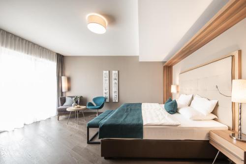 a bedroom with a large bed and a desk at ALPIANA - green luxury Dolce Vita Hotel in Vollan