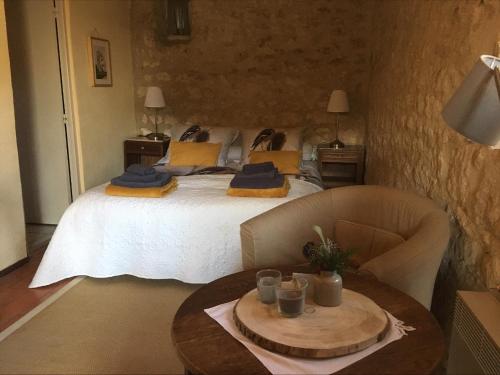 a bedroom with a large bed with a table in it at Les Gonies - Amande in Mauroux