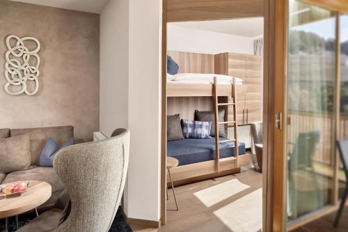 a living room with a couch and a bunk bed at ALPIANA - green luxury Dolce Vita Hotel in Vollan