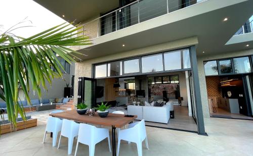 a dining room with a table and white chairs at Beyond Paradise in Knysna