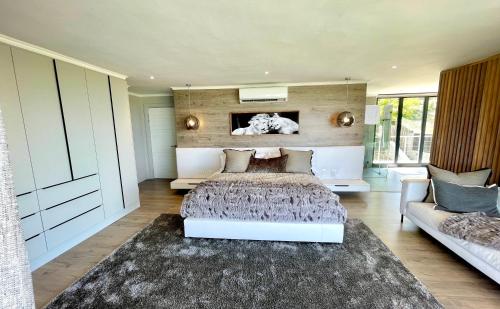 a bedroom with a large bed and a couch at Beyond Paradise in Knysna