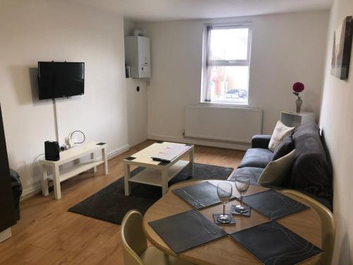 a living room with a couch and a table at 2 Bedroom Large First Floor Apartment with FREE Parking in Loughborough