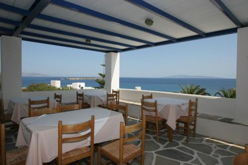 a dining room with tables and chairs and the ocean at Silver Rocks Hotel in Chrissi Akti
