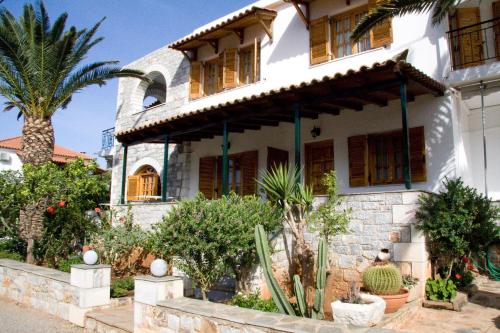 a house with a palm tree in front of it at Anna Maria Studios in Agios Nikolaos