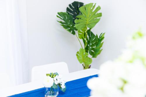 a blue table with a vase with flowers on it at Awaji Garden House in Shinmura in Sumoto
