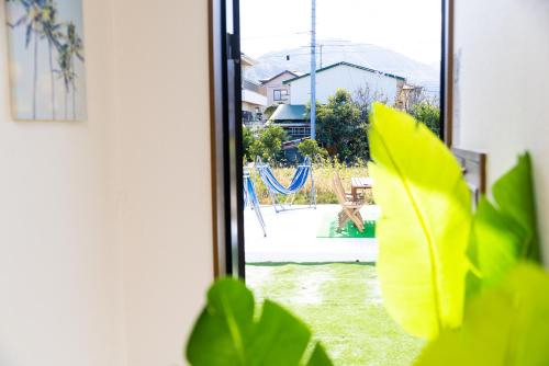 a window with a view of a yard with a playground at Awaji Garden House in Shinmura in Sumoto