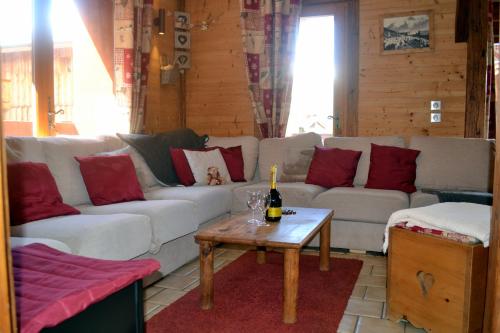 - un salon avec un canapé blanc et des oreillers rouges dans l'établissement Chalet Versoye, Montchavin-La Plagne, à Landry