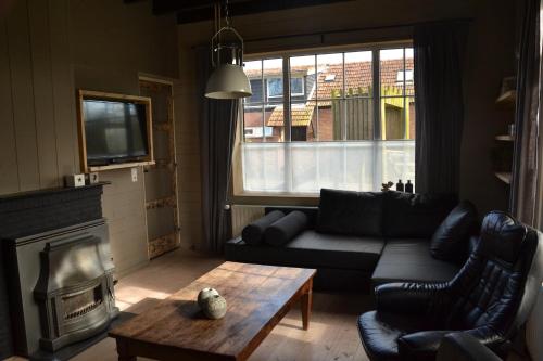 a living room with a couch and a fireplace at Vakantiewoning Boerderij De Gerrithoeve in Oisterwijk