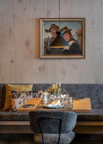 a dining room with a table and a painting on the wall at Ski & Bike Hotel Wiesenegg in Saalbach Hinterglemm