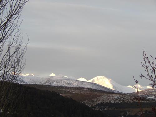 una montaña cubierta de nieve en la distancia con montañas en el fondo en Casas Rurales Cimera yBrincalobitos, en Hoyos del Espino