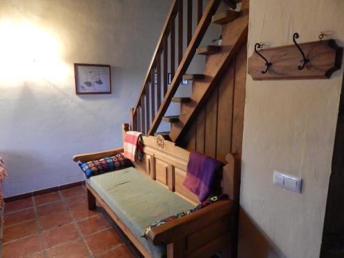 escalera de madera en una habitación con escalera en Casas Rurales Cimera yBrincalobitos, en Hoyos del Espino