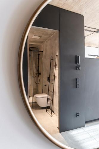 a bathroom with a toilet and a mirror at Pförtner Penthouse in Hausham