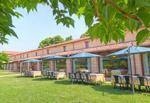a group of tables and chairs in front of a building at Hotel La Foresteria in Abbadia di Fiastra