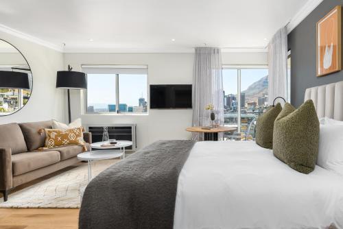 a bedroom with a large bed and a couch at Point Break Luxury Apartments in Cape Town