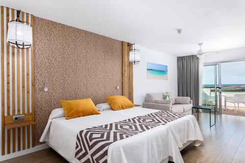 a bedroom with a large bed and a living room at Cotillo Sunset in El Cotillo