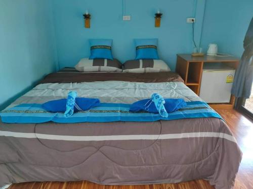 a bedroom with a large bed with blue walls at Kohmook Happy time Bungalow in Koh Mook