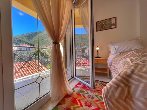 ein Schlafzimmer mit einem Bett und einem großen Fenster in der Unterkunft "Mykines" Apartment of Levidi Arcadian Apartments in Leonidi