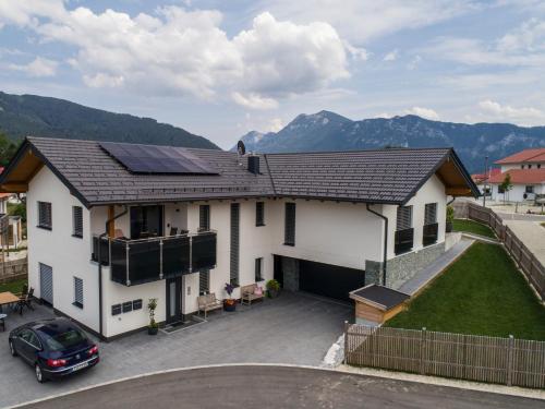 a white house with solar panels on the roof at Ferienwohnungen Mountainfloor - Chiemgau Karte in Inzell