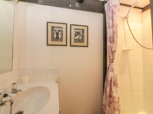 a bathroom with a sink and two pictures on the wall at Lilac Cottage in Paignton
