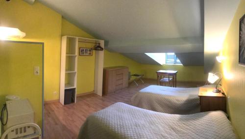 a bedroom with two beds in a room with yellow walls at Chateau de Faudade in Lévignac-sur-Save