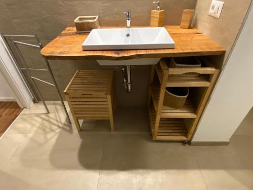 ein Badezimmer mit einem Waschbecken und einer Holztheke in der Unterkunft EM home01 in Cattolica