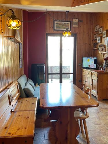 - un salon avec une table en bois et un canapé dans l'établissement Appartamento Le Betulle, à Erbezzo