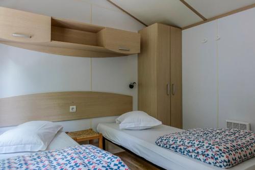 2 camas en una habitación pequeña con 2 camas sidx sidx sidx en Camping Siena Colleverde, en Siena