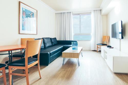 a living room with a couch and a table at Almog Haifa Israel Apartments מגדלי חוף הכרמל in Haifa