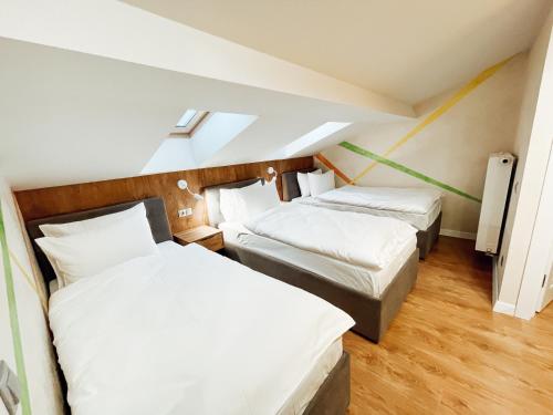 two beds in a room with white sheets at Mountain Residence Apartments & Chalet in Bukovel