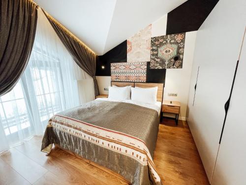a bedroom with a bed and a large window at Mountain Residence Apartments & Chalet in Bukovel