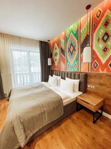 a bedroom with a large bed and a large painting at Mountain Residence Apartments & Chalet in Bukovel