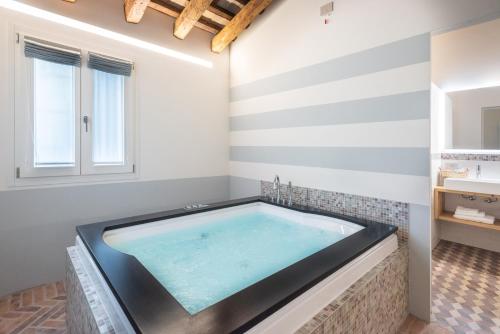 a jacuzzi tub in a bathroom with striped walls at Relais Barchessa Molon in Campo di Pietra