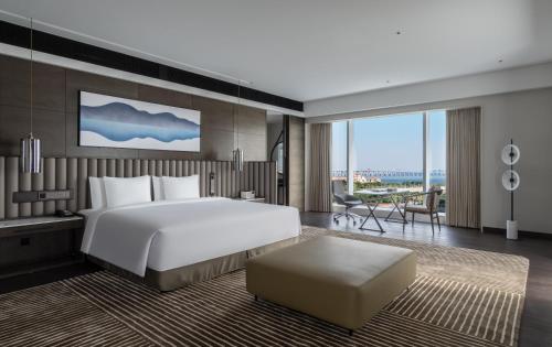 ein Schlafzimmer mit einem großen Bett und ein Wohnzimmer in der Unterkunft Crowne Plaza Xiamen Jimei Seaview, an IHG Hotel-Free Mini Bar in Xiamen